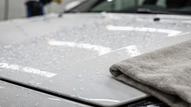 Gepflegte Autolackoberfläche mit Wassertropfen zum Thema Autowachs-Haltbarkeit