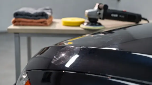 Autolack mit Hologrammen nach dem Polieren in einer Werkstatt mit Poliergerät und Mikrofasertuch