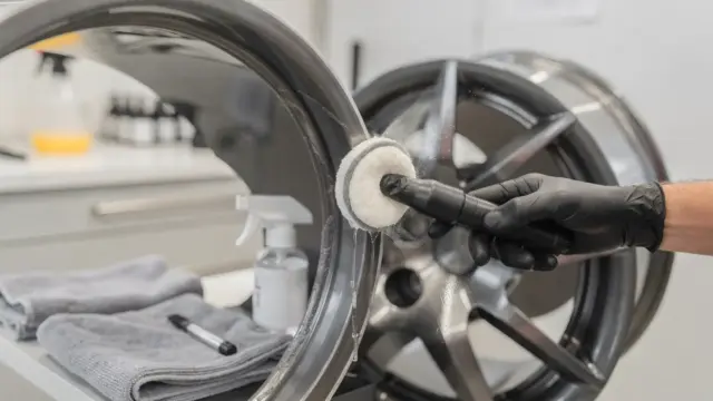Felgen versiegeln: Detailer trägt Schutz auf gereinigte Autofelge in der Werkstatt auf